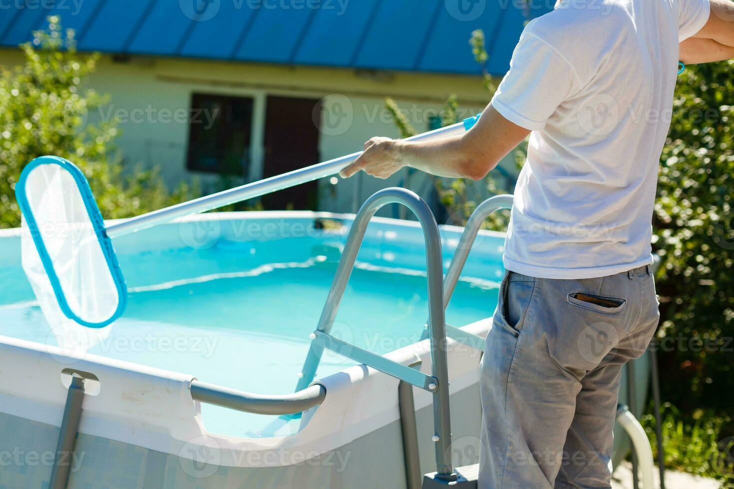 hombre limpieza el piscina a su país casa. verano a hogar concepto. estilo de vida foto