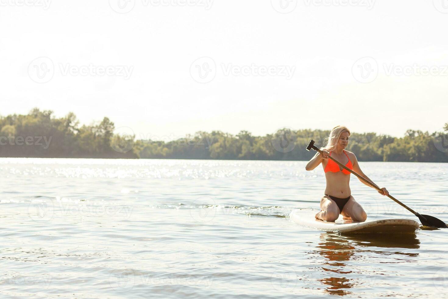 A beautiful woman practicing paddle on a beautiful sunny day photo