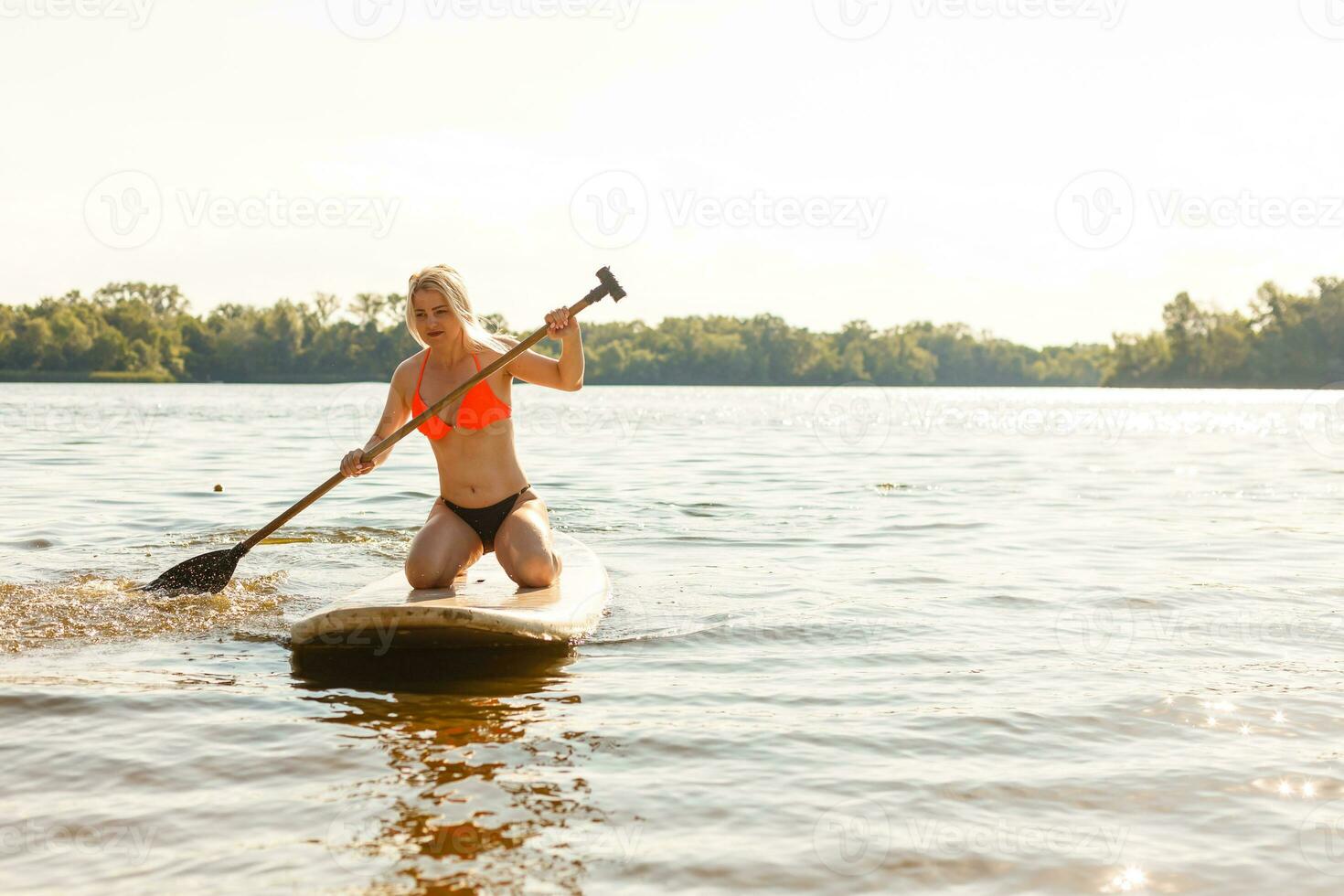 Young teenager girl in swimsuit holding supboard on the beach. AI