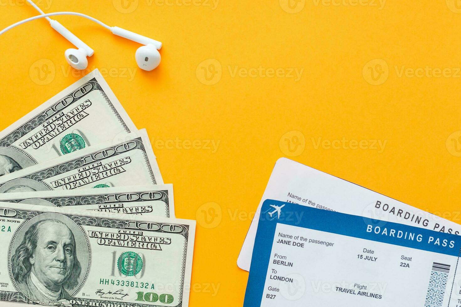 tourism, travel and objects concept - air ticket, money, over yellow concrete background photo