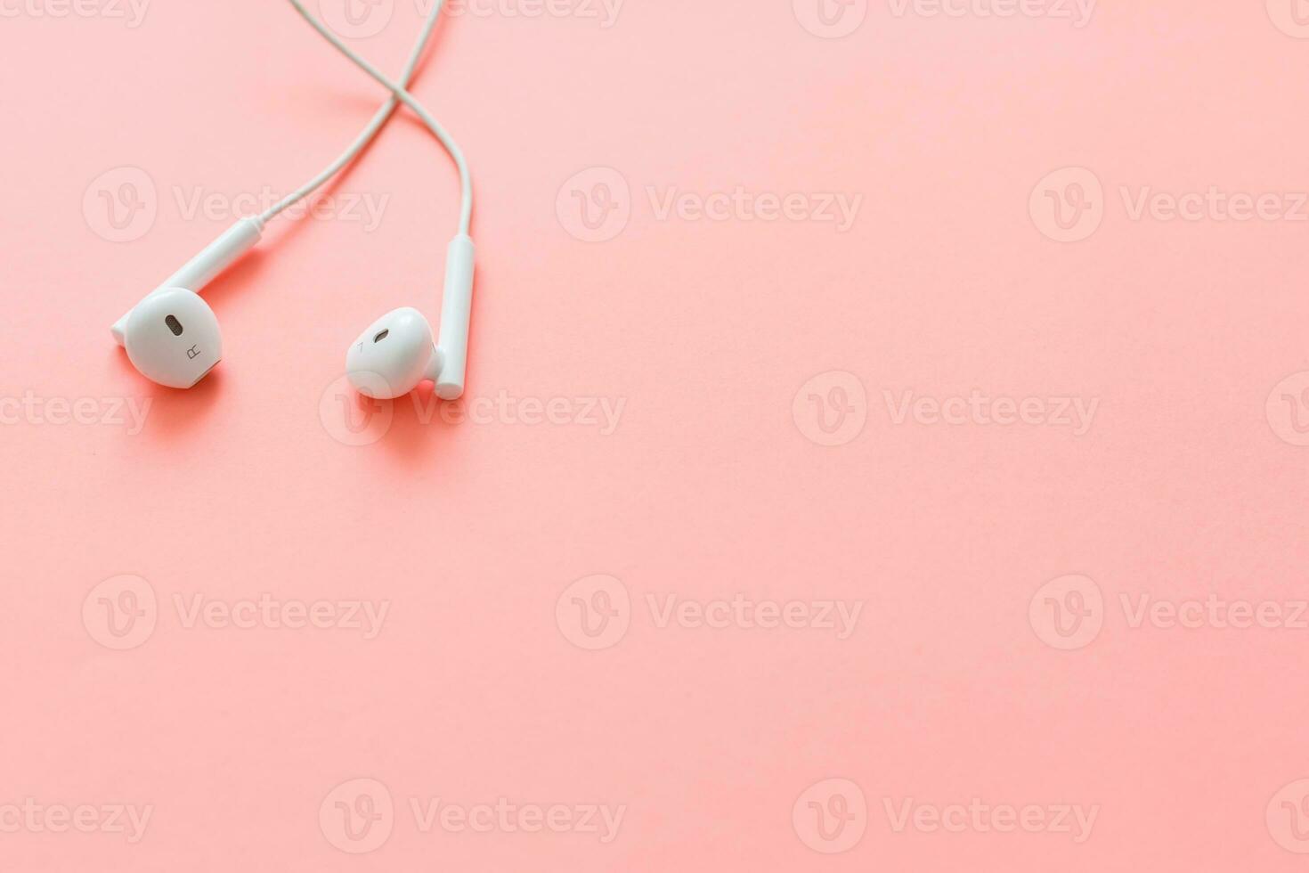 plano laico concepto auriculares en pastel antecedentes. auriculares en un rosado fondo, parte superior vista, espacio de copia. de moda vistoso foto. mínimo estilo con vistoso papel fondo. foto