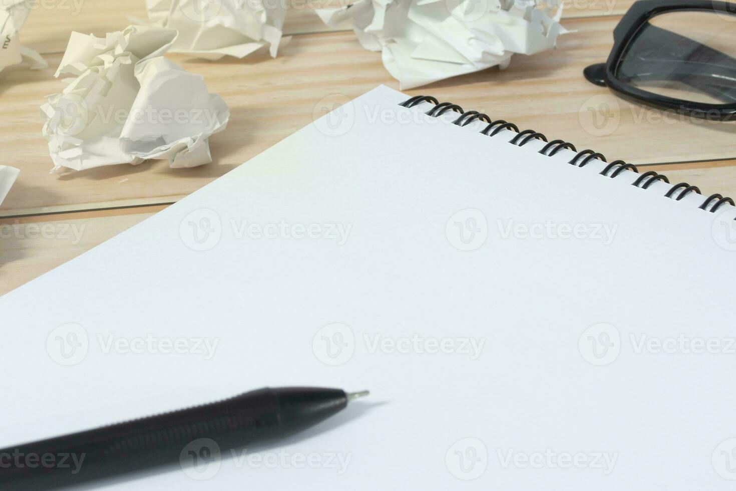 Notepad with trash paper background on wooden desk. photo