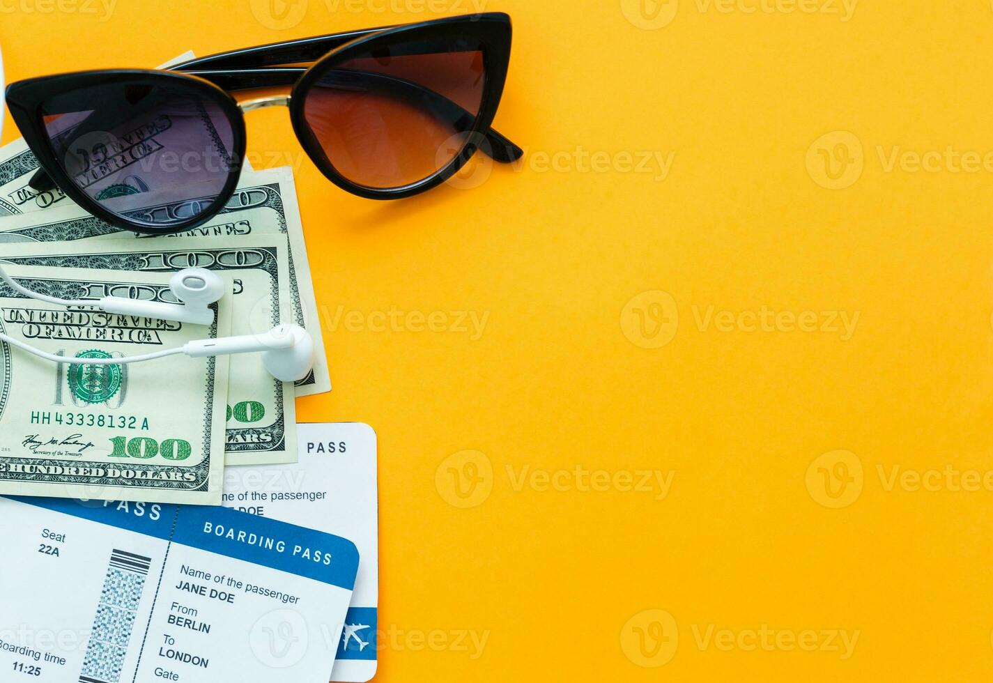 tourism, travel and objects concept - air ticket, money, over yellow concrete background photo