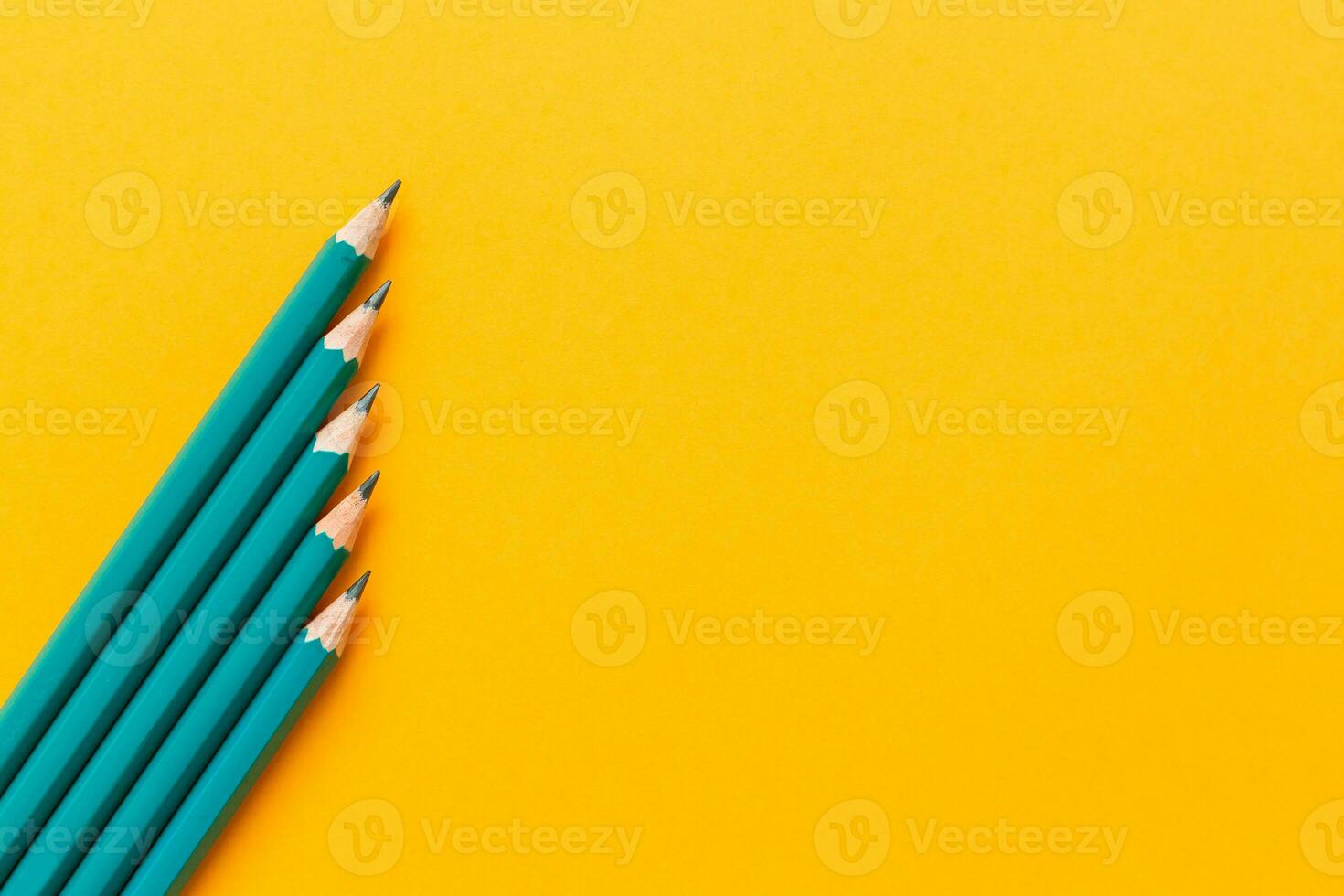 Template with copy space by top view close up macro photo of wooden pencils isolated on yellow paper that look minimalist and clean.