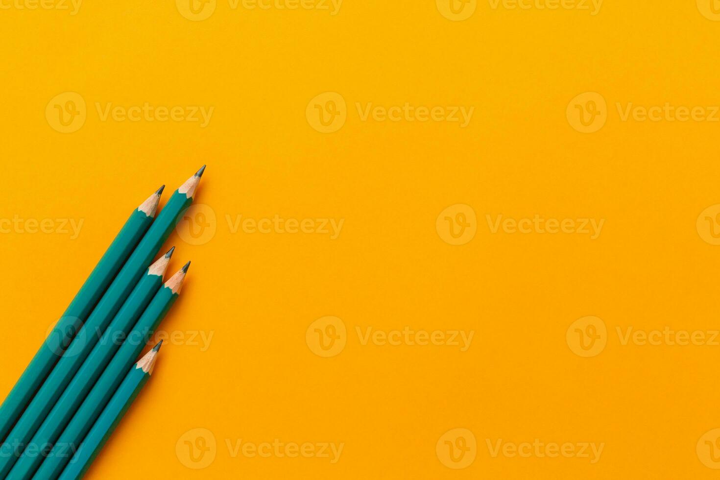 Template with copy space by top view close up macro photo of wooden pencils isolated on yellow paper that look minimalist and clean.