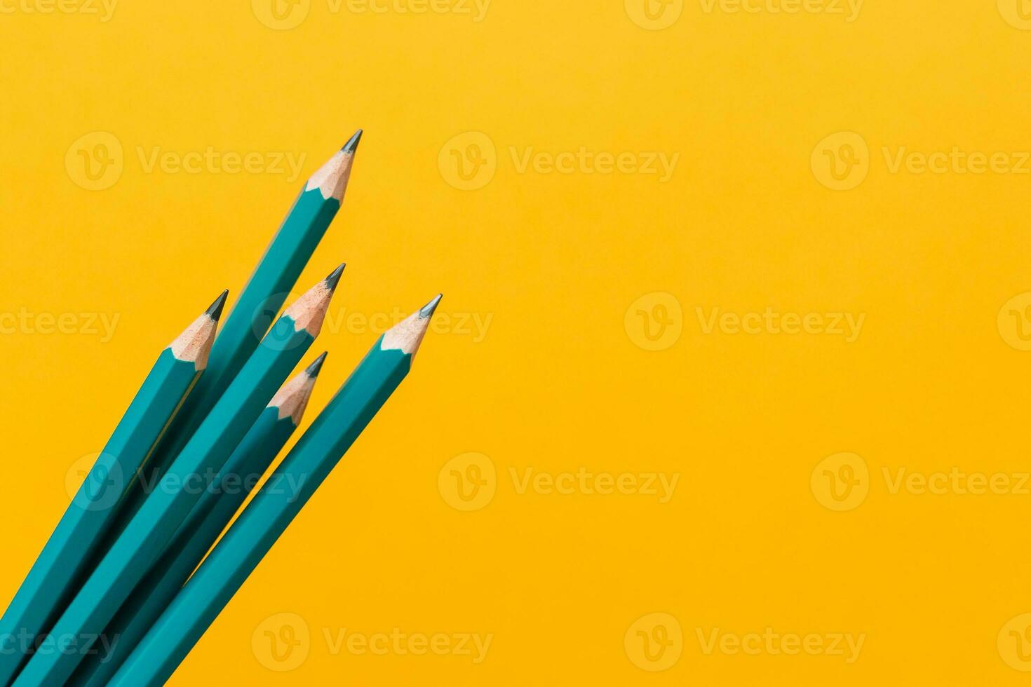 Template with copy space by top view close up macro photo of wooden pencils isolated on yellow paper that look minimalist and clean.