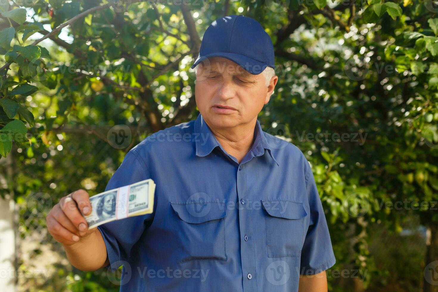 An elderly man holding a stack of money photo