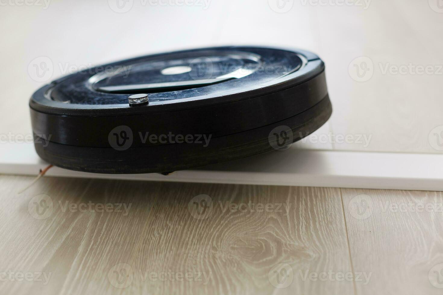 The automated robot vacuum cleaner of a roundish form, can make cleaning in hard-to-reach spots. photo