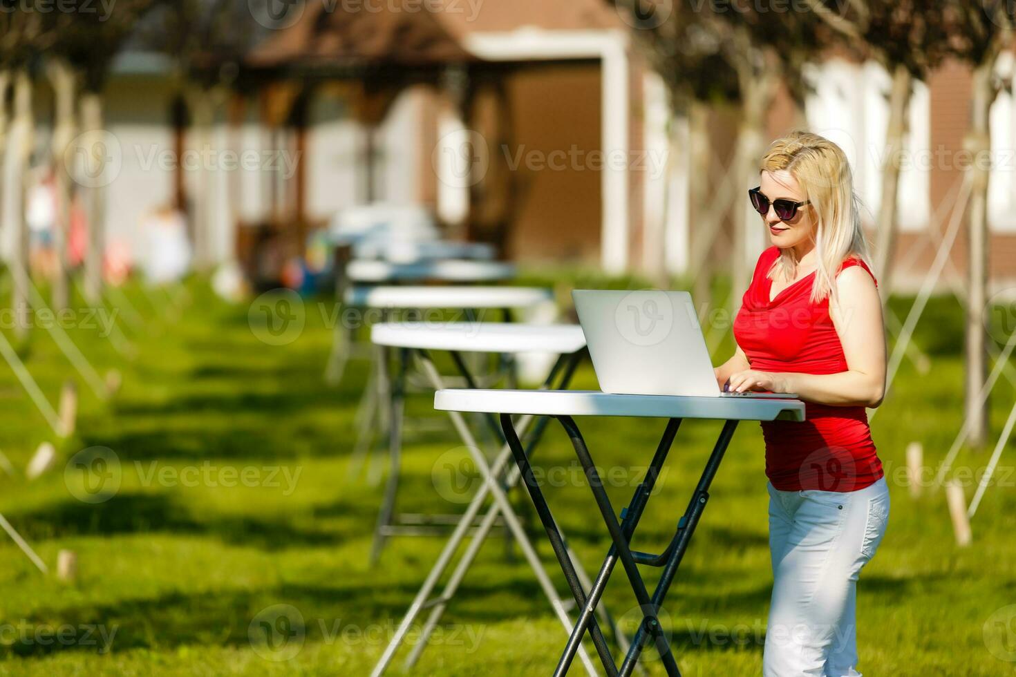 Portrait of a woman buying online or booking hotel with a laptop and credit card on the beach in vacations. E commerce concept photo