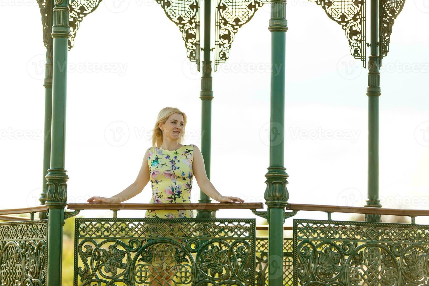 A woman in sunglassesnst the background of a fountain. photo