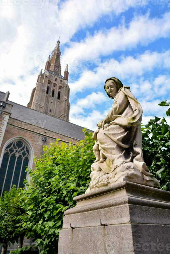 statue of a person in front of the cathedral photo