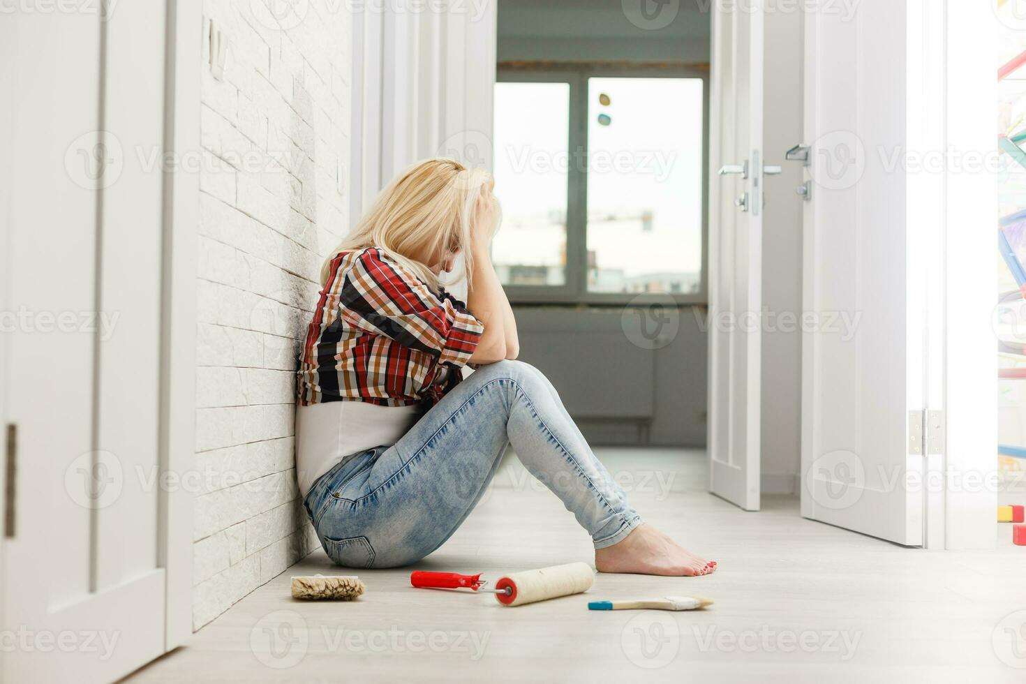 woman make repair stick wallpaper have a headache portrait on the white wall background photo