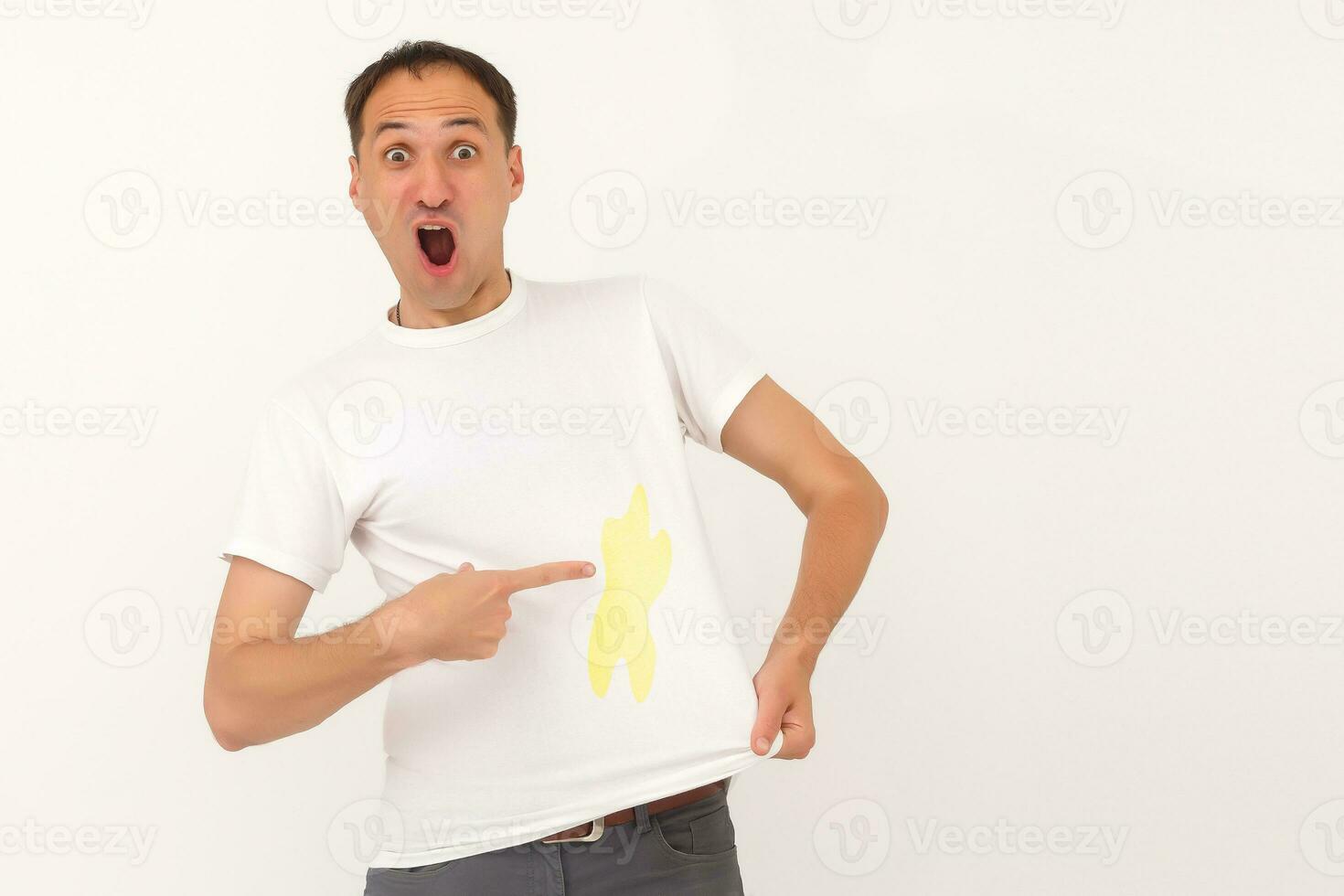 man shows a stain on his white t-shirt photo