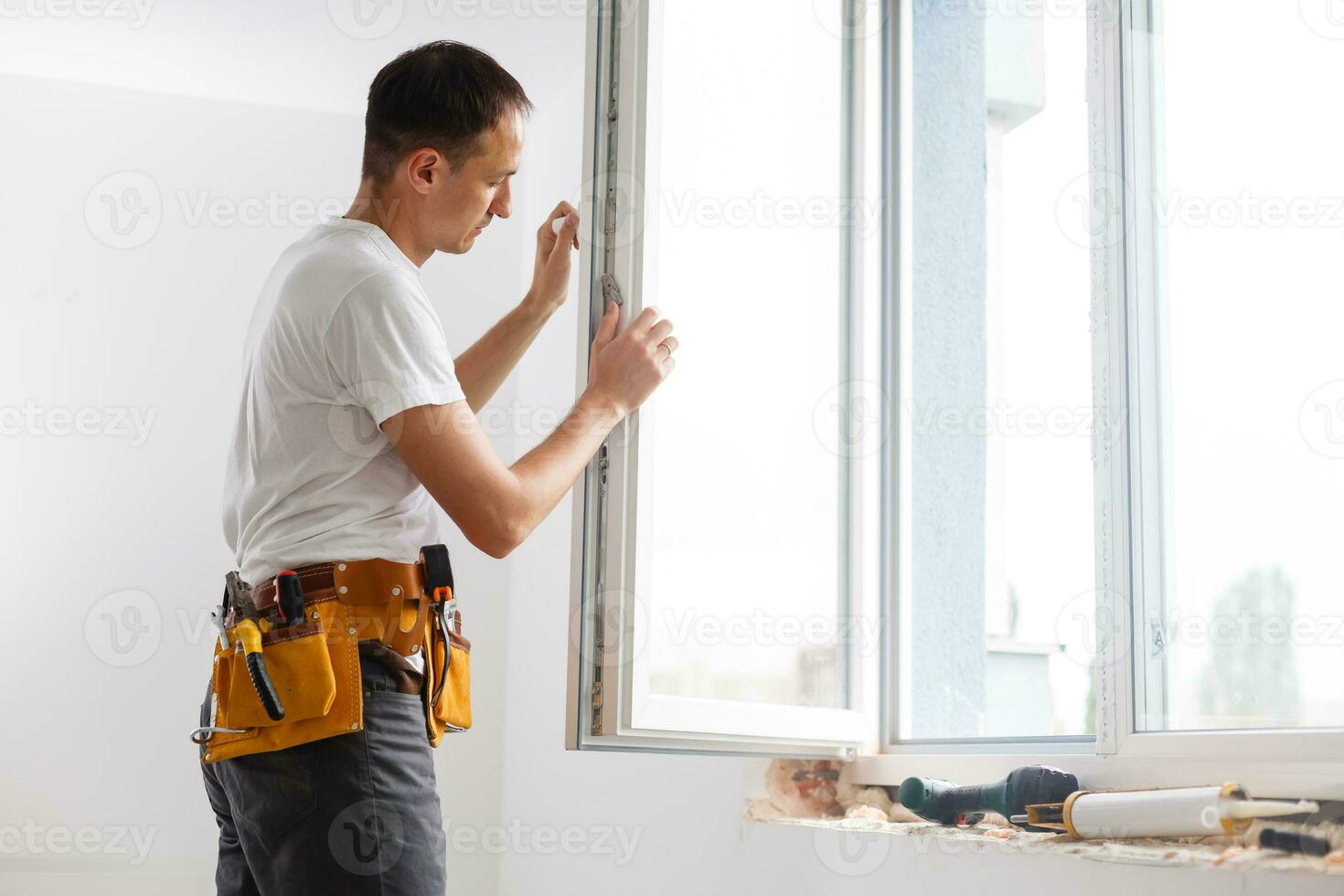 male industrial builder worker at window installation in building construction site photo