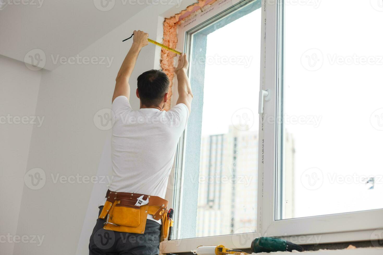 Young handyman repair window with screwdriver photo