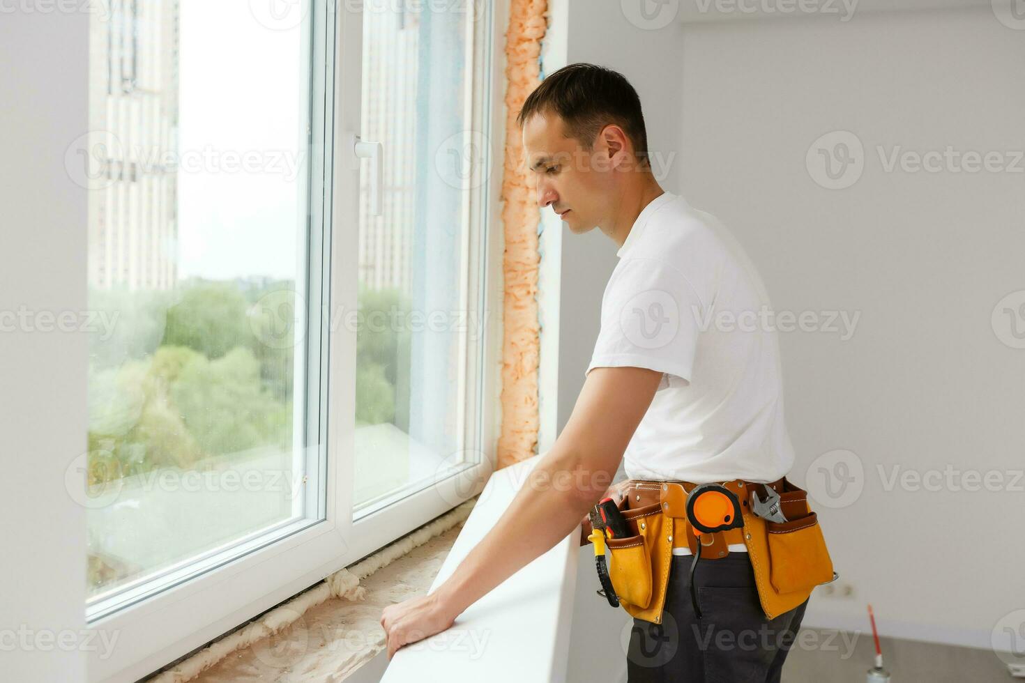 Young handyman repair window with screwdriver photo