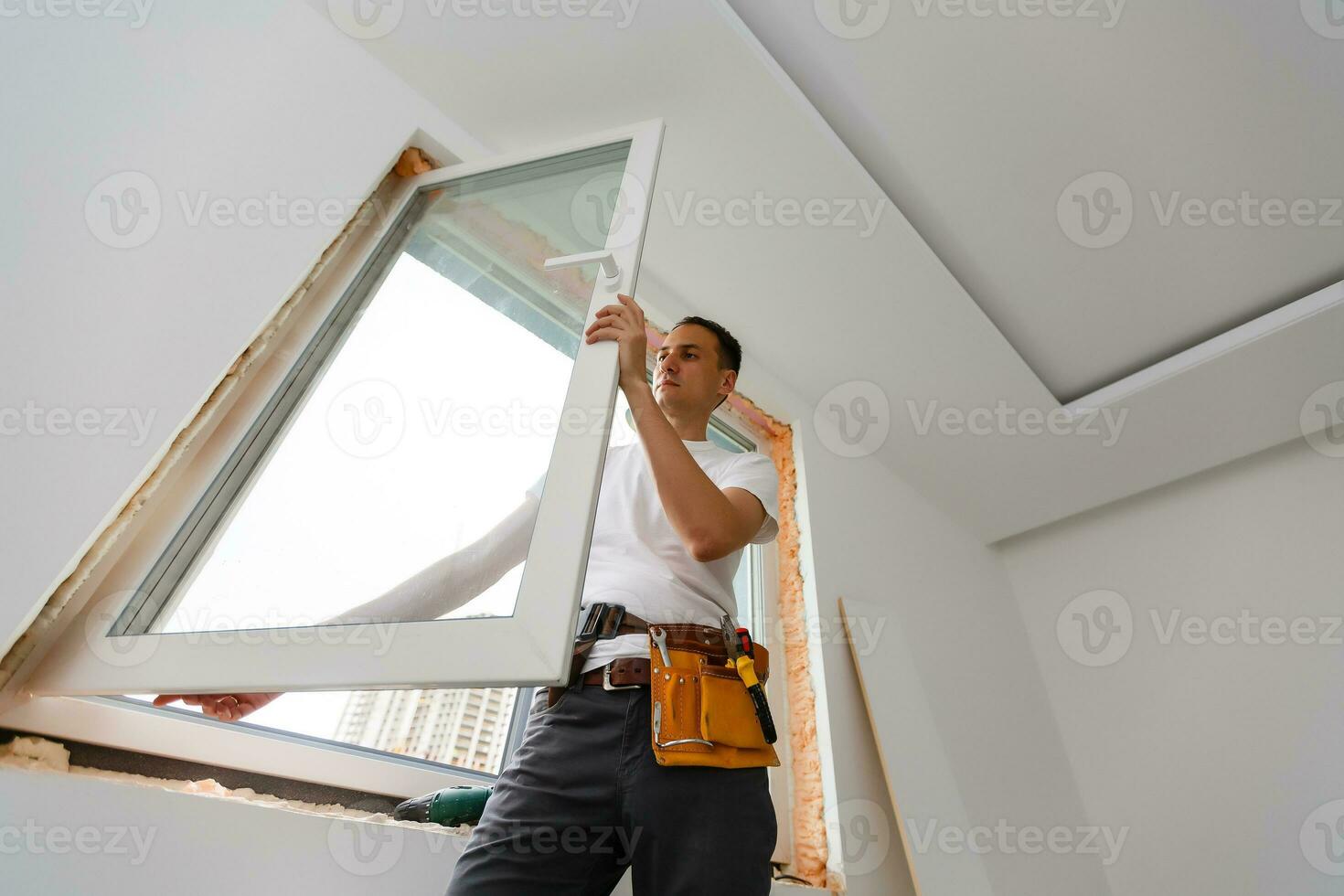 Young handyman repair window with screwdriver photo