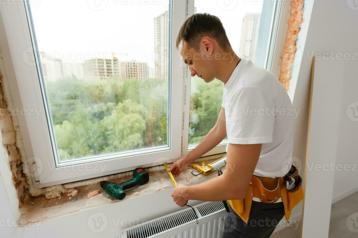 Young handyman repair window with screwdriver photo