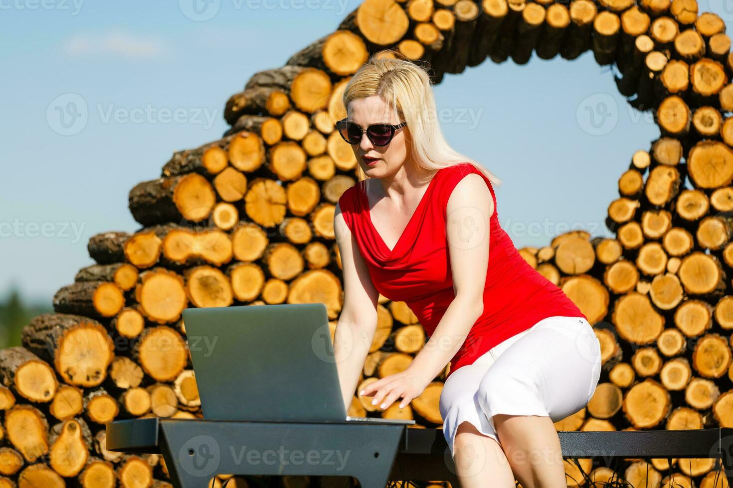 Young pretty woman with laptop on the bench in a park photo