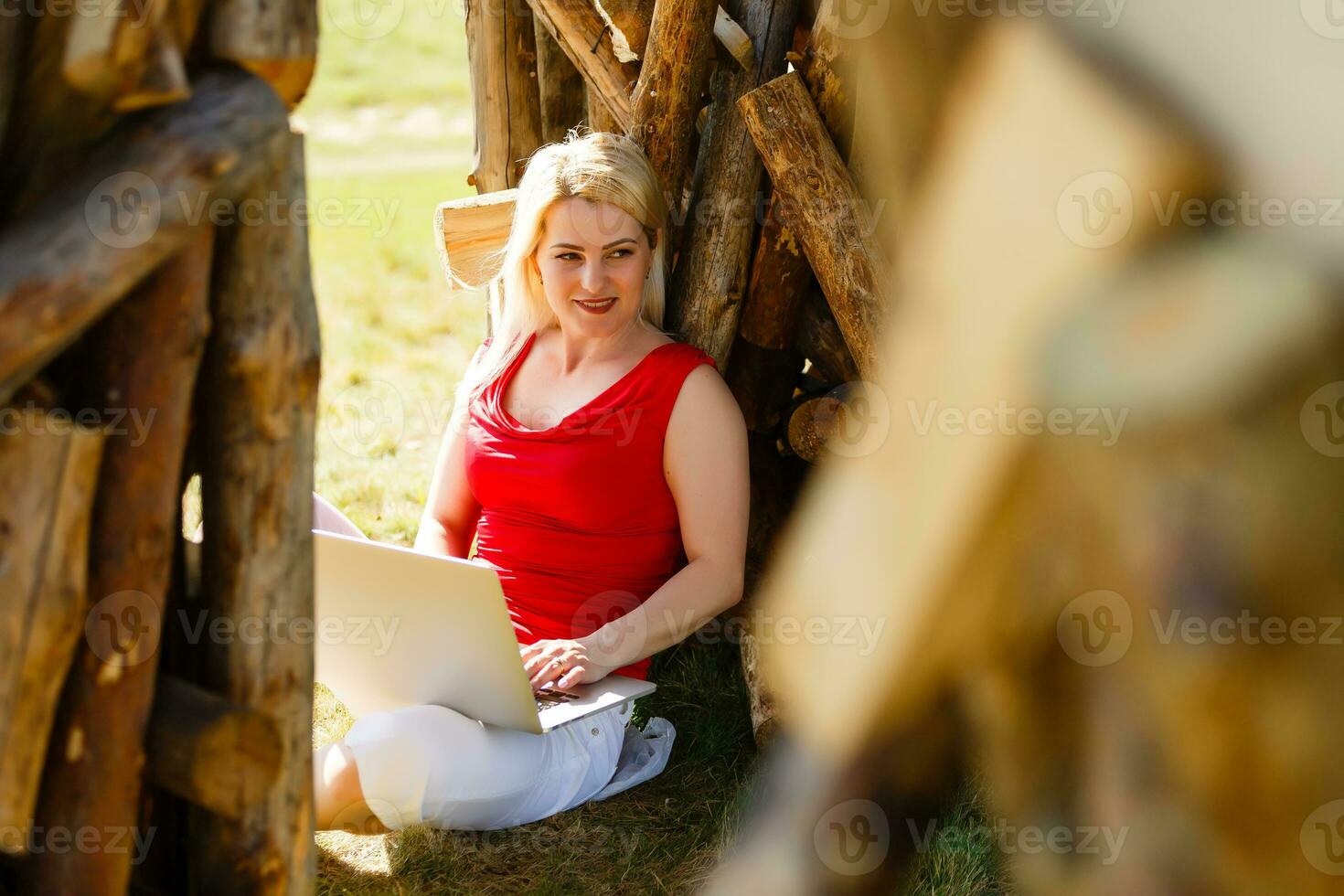 Euphoric woman searching job with a laptop in an urban park in summer photo