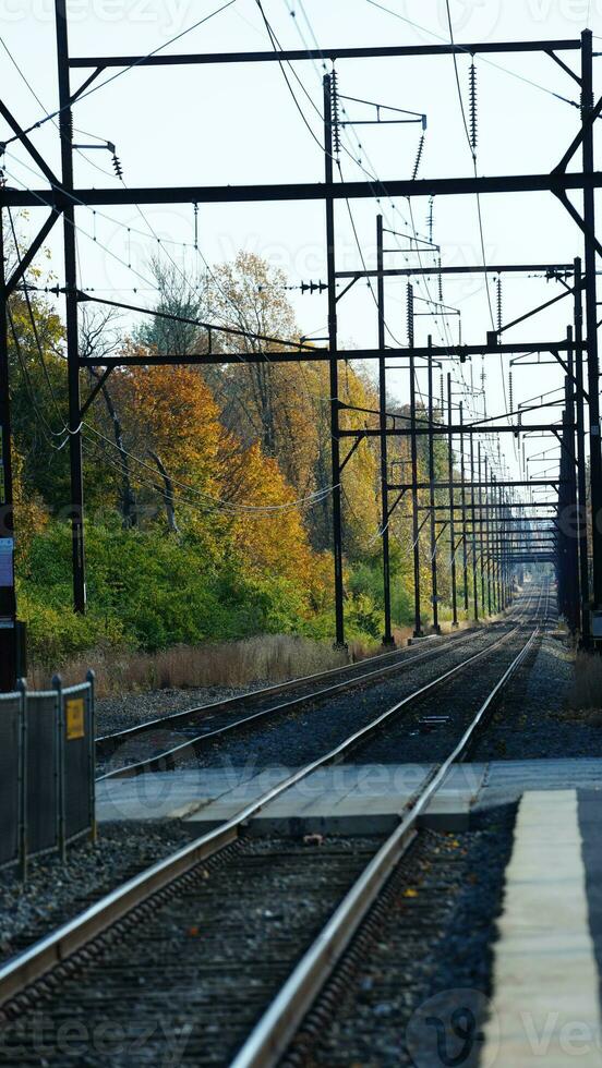 The railroad view with the parallel iron tracks and platform as background photo