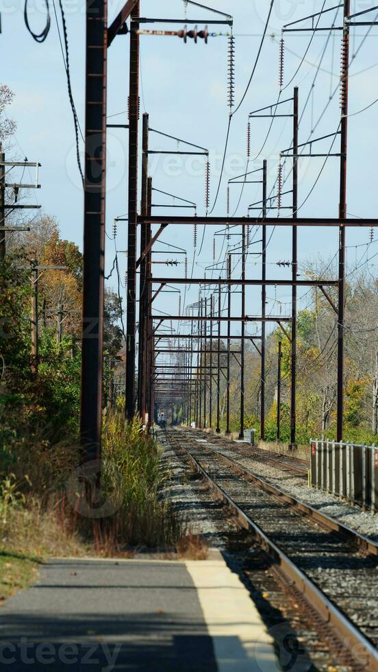 The railroad view with the parallel iron tracks and platform as background photo