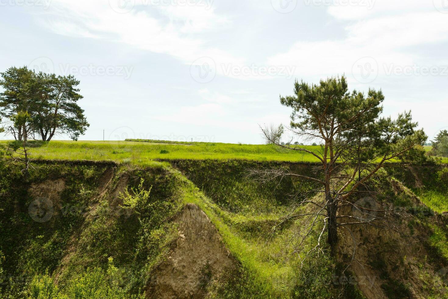 Spring photography, meadows, fields, ravines, hills, rural landscape. A deep, narrow gorge with steep slopes. A naturally raised area of land, not as high or craggy as a mountain. photo