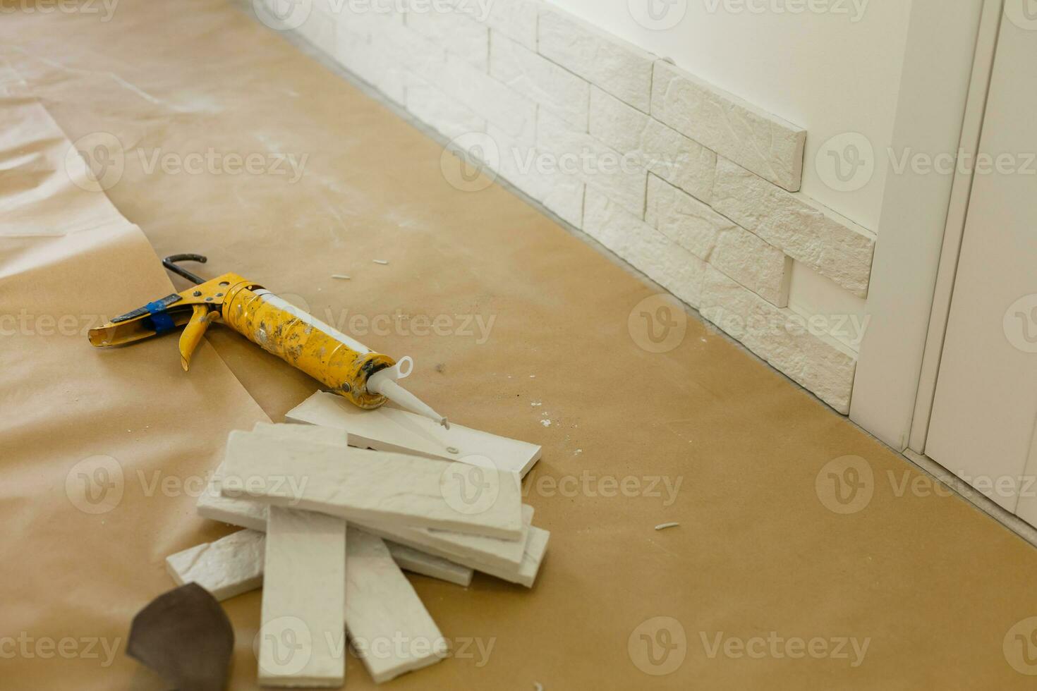 Professional Builder gluing decorative tile on wall. worker mounts decorative brick on wall photo