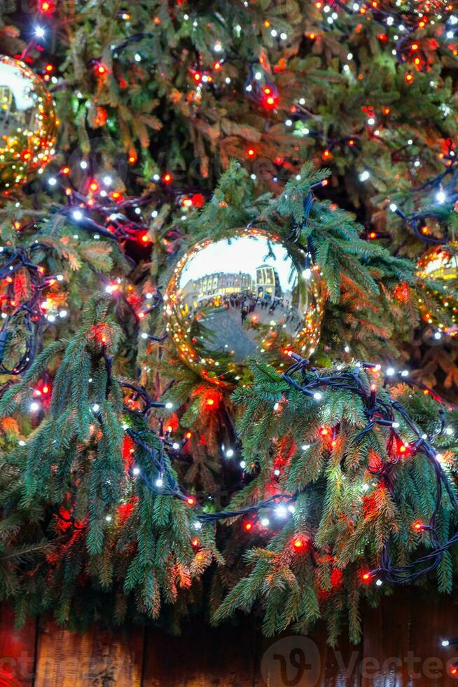 Decorated illuminated outside christmas tree showing reflection of Covent Garden, London, in a golden bauble photo