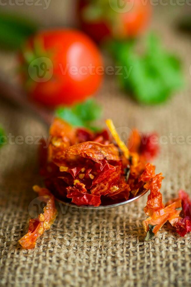 small pieces of dried tomatoes next to fresh tomatoes photo