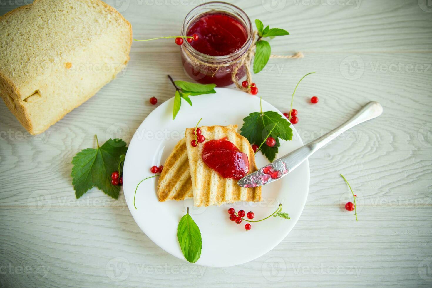 fried bread croutons for breakfast with redcurrant jam in a plate with berries photo
