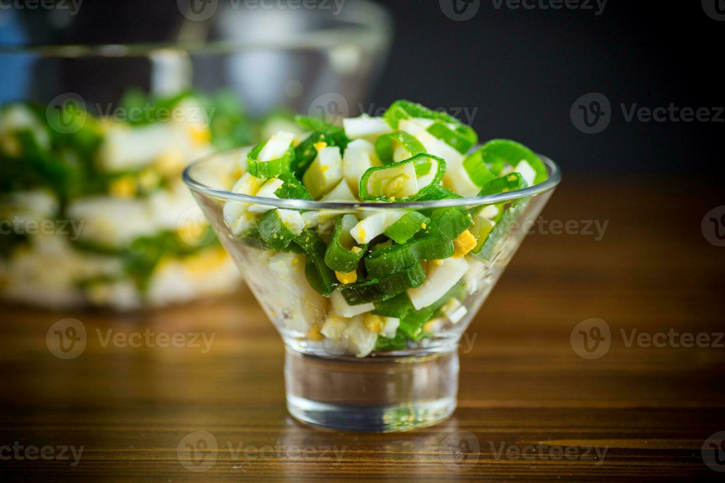 fresh spring salad with boiled squid, boiled eggs and green onions photo