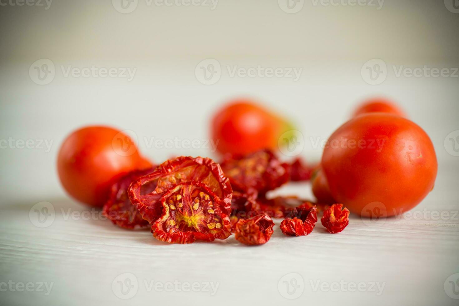 a handful of dried tomatoes and fresh tomatoes photo