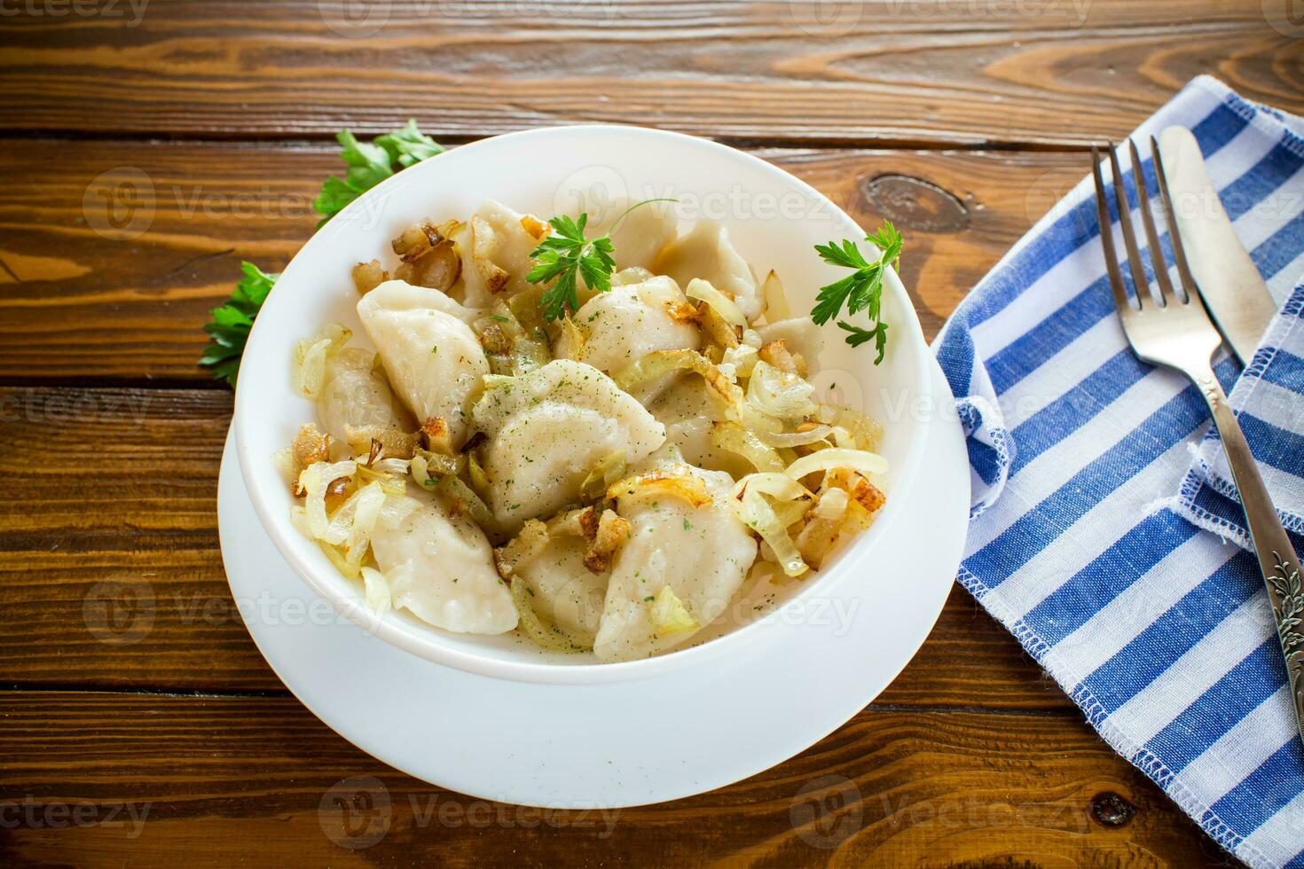 Ukrainian dumplings stuffed with potatoes and mushrooms, served with fried onions. photo