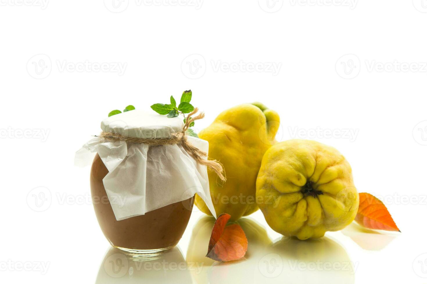 Ripe quince fruit with jam in a glass jar isolated on a white background. photo