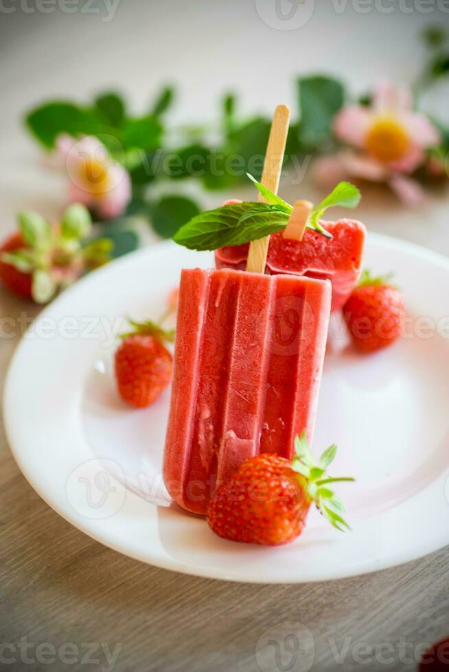 homemade strawberry ice cream on a stick made from fresh strawberries in a plate photo