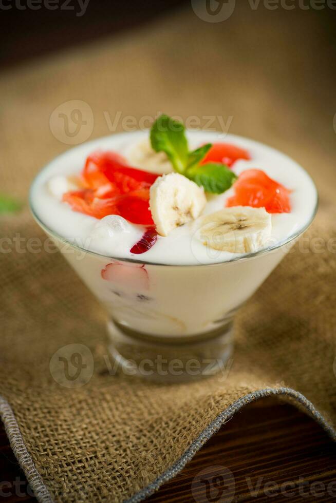 homemade sweet yogurt with bananas and pieces of fruit jelly photo
