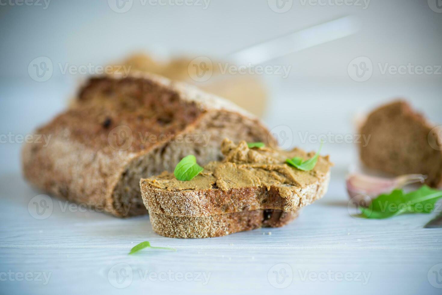 homemade liver pate with bread on a wooden table photo