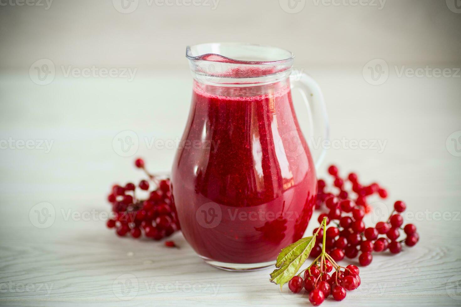 freshly squeezed thick natural juice with pulp from ripe red viburnum in a decanter photo