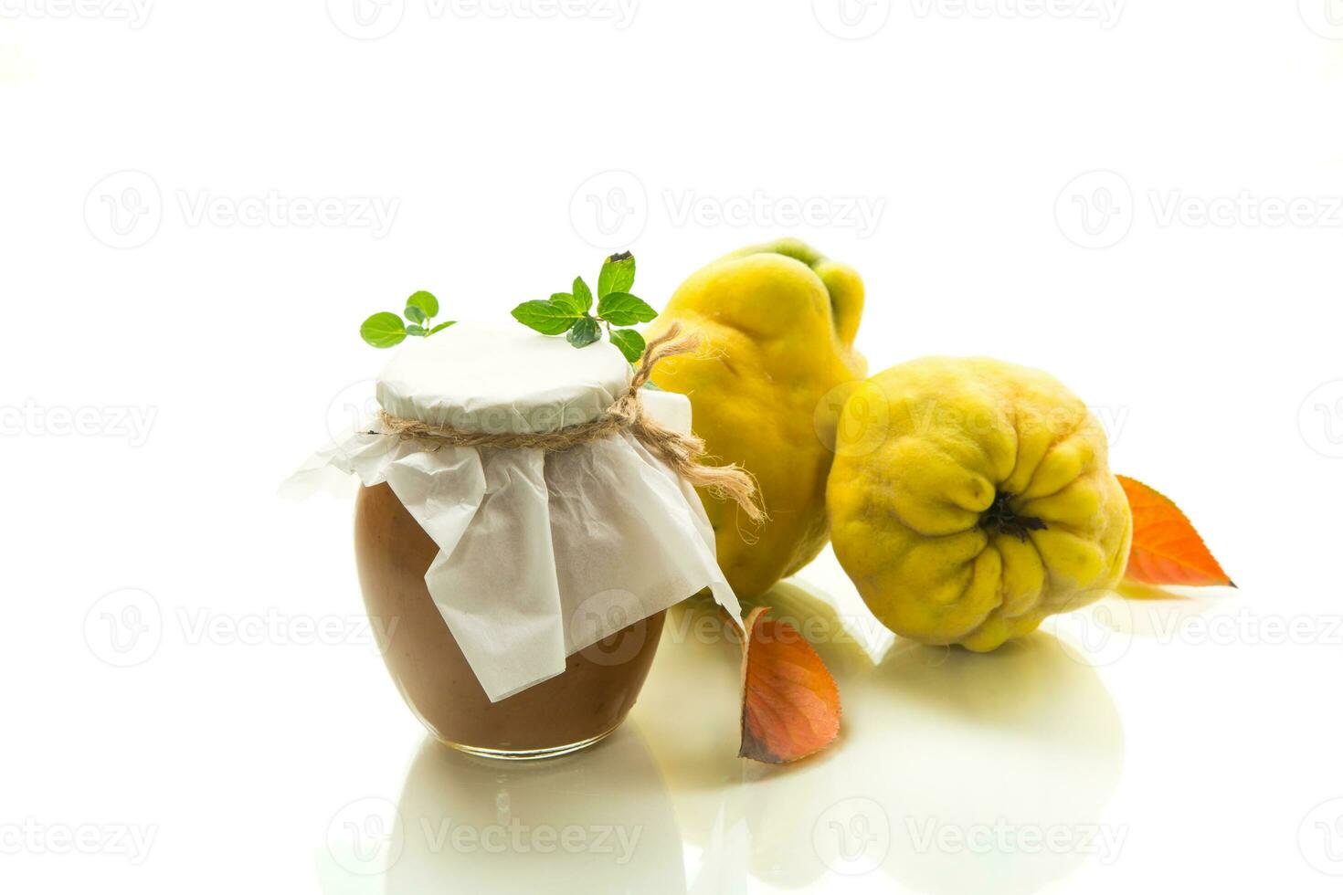 Ripe quince fruit with jam in a glass jar isolated on a white background. photo