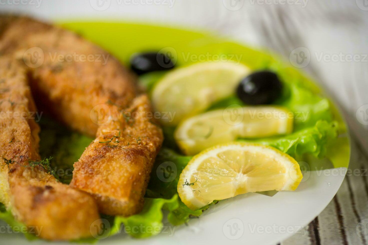 pedazo de frito salmón pescado en un plato con limón foto