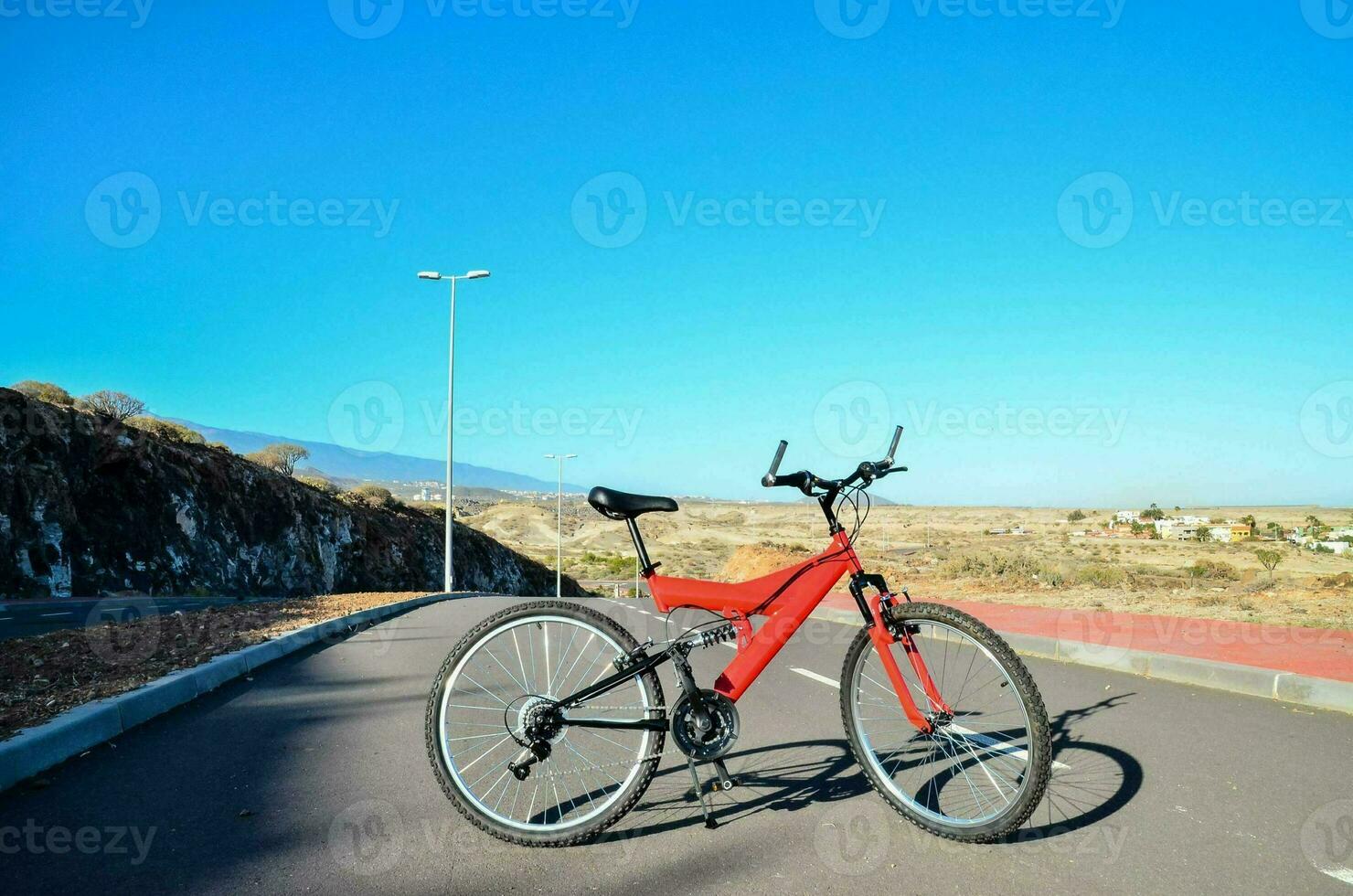 un rojo bicicleta estacionado en el lado de el la carretera foto