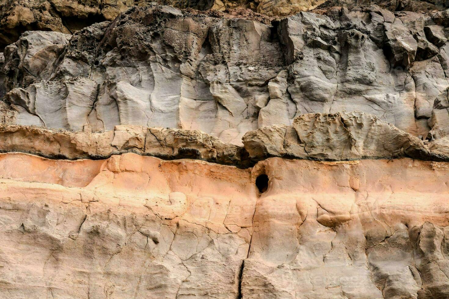 a rock face with orange and brown colors photo