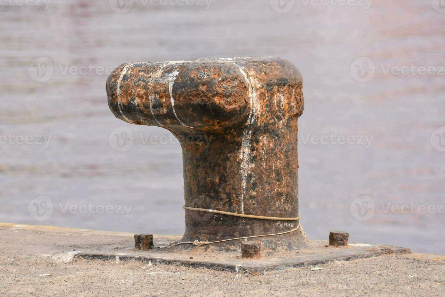 a rusty metal post on the side of a dock photo