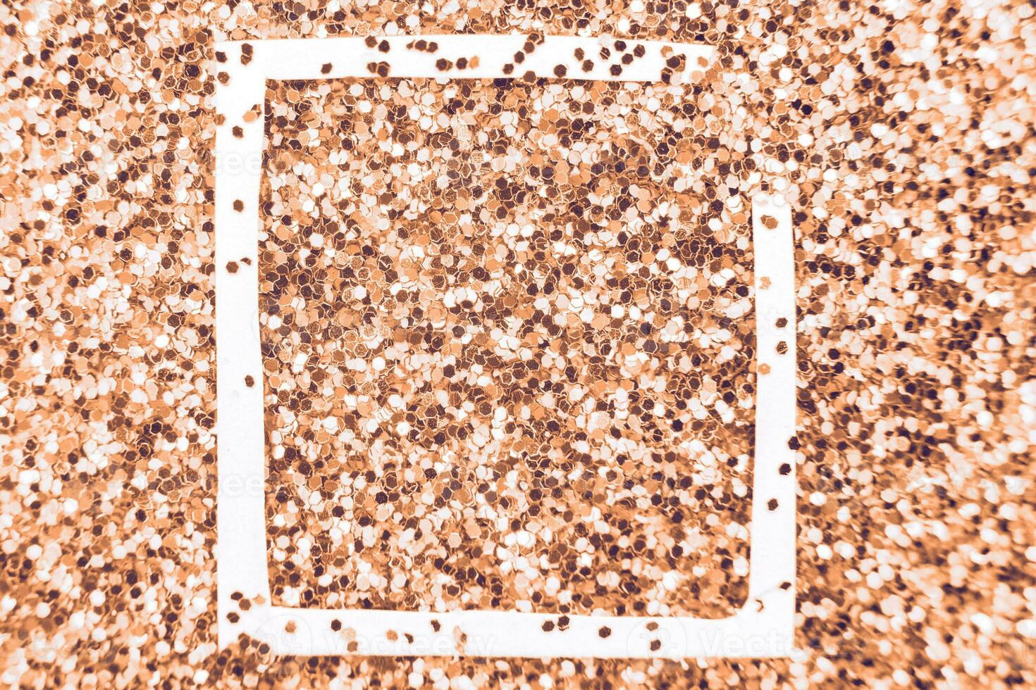 glittering background of Peach Fuzz sequins closeup. Sparkle festive texture. white frame for your text photo
