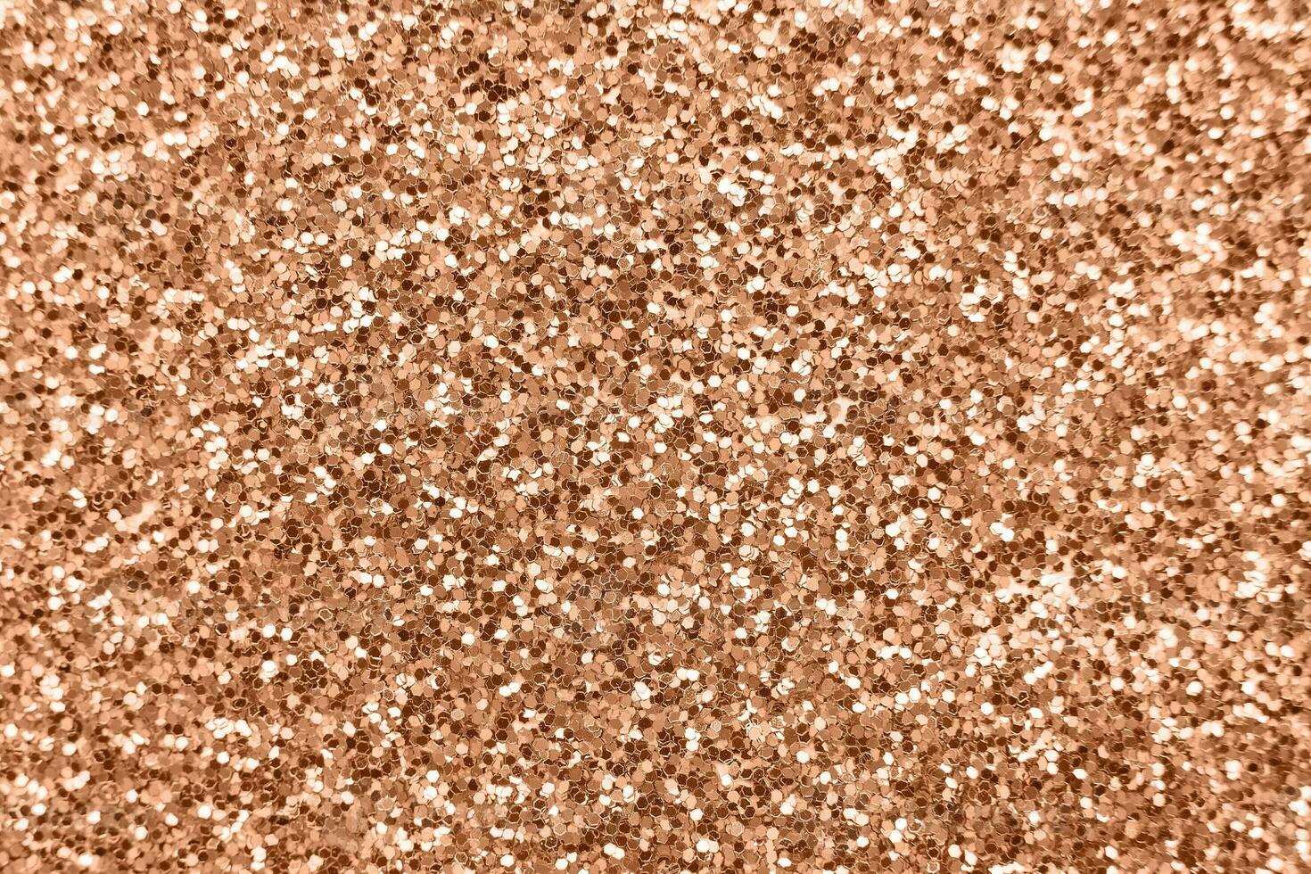 glittering background of Peach Fuzz sequins closeup. Sparkle festive texture photo