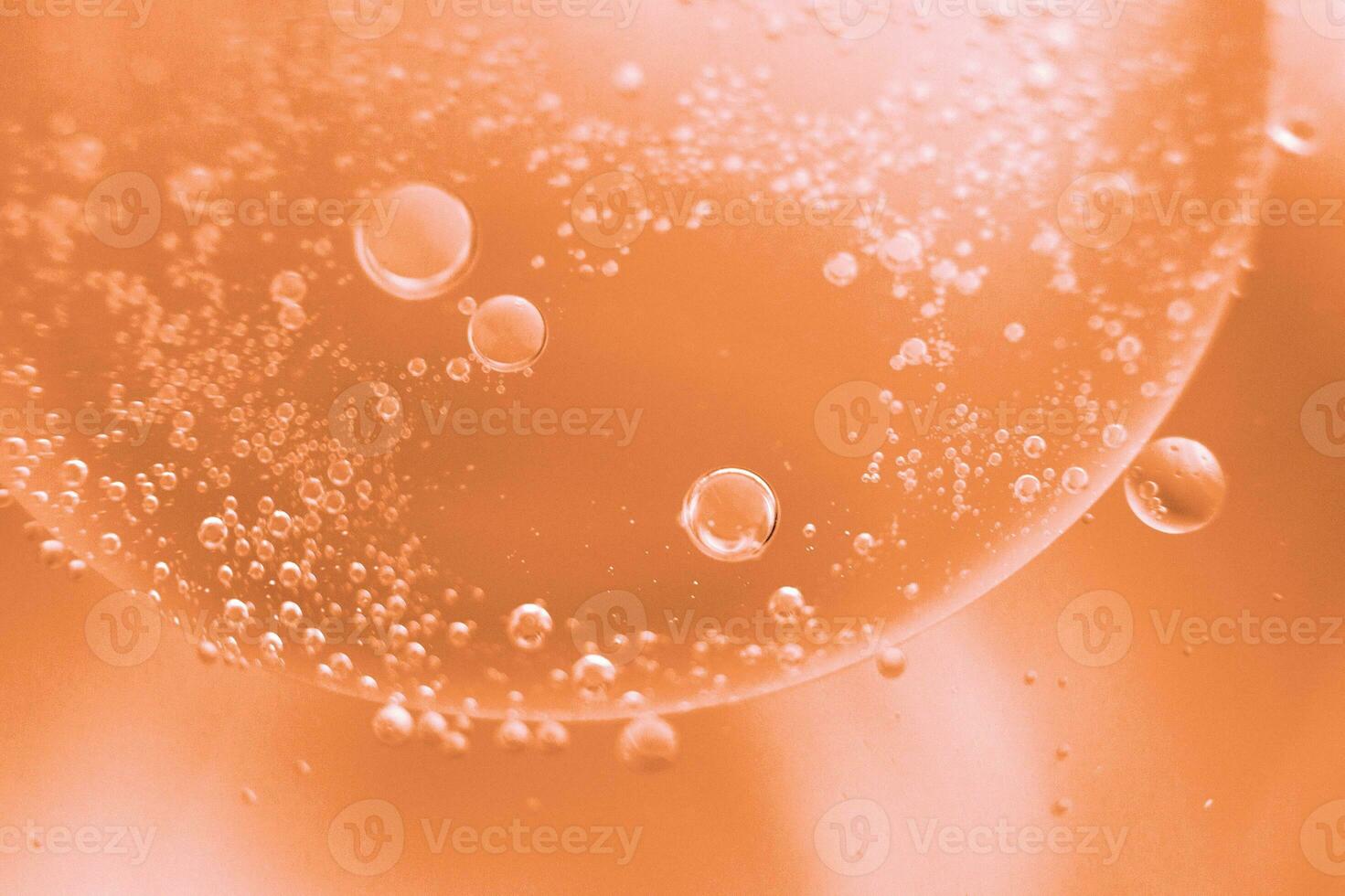 abstract light Peach Fuzz background with oil circles . bubbles of water close up photo