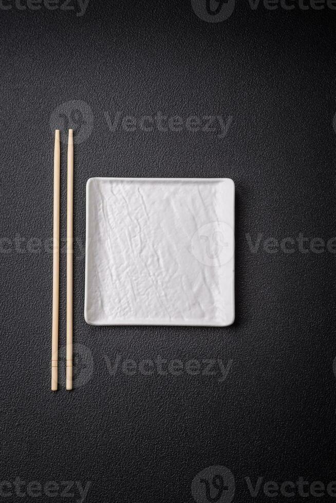 Square empty ceramic plate on textured concrete background photo
