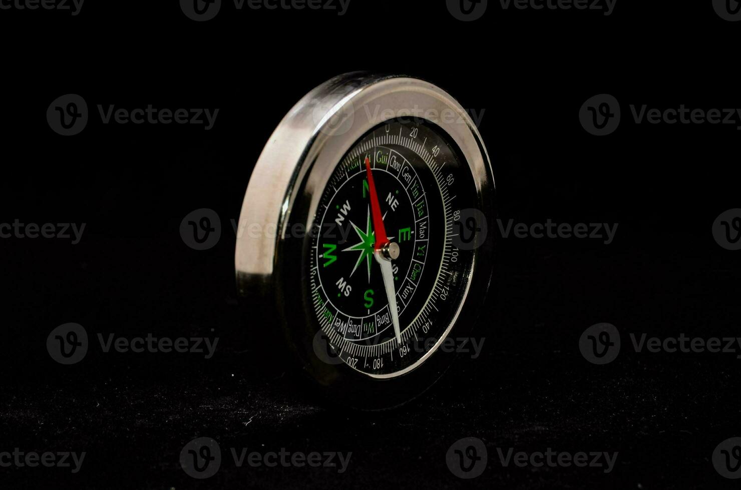 a silver compass on a black background photo