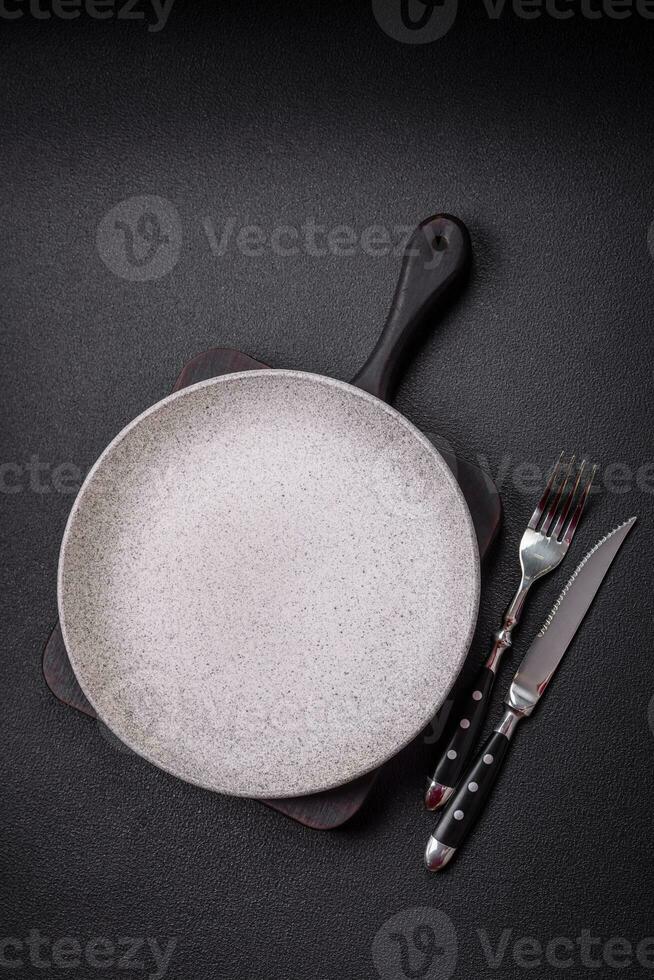 Bumpy empty ceramic plate on a textured concrete background photo